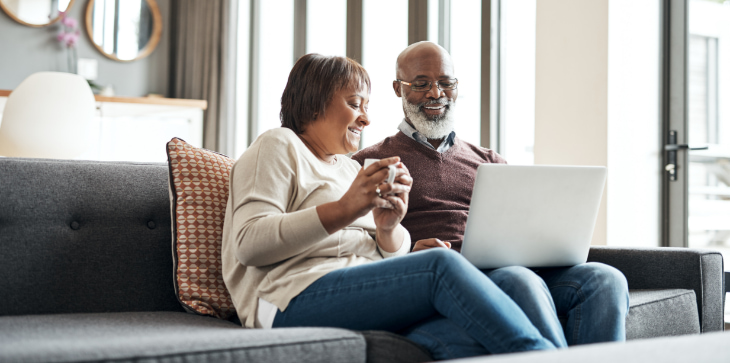 Elderly couple smiling at laptop