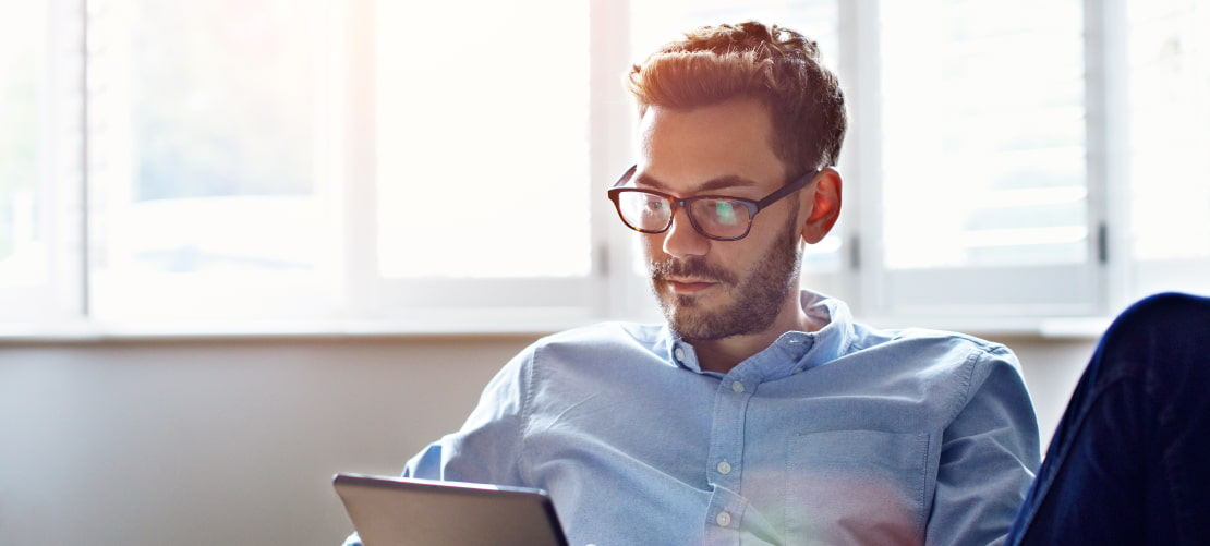 Man with glasses sunlight on tablet