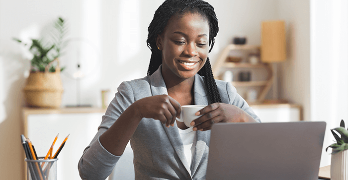 Investor reading income statements Woman smiling in front of laptop