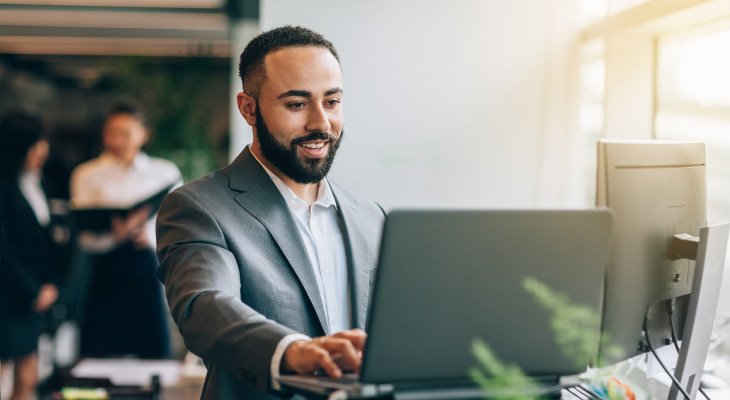 Man with beard and suit laptop and extra monitor