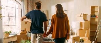Couple holding hands while packing boxes