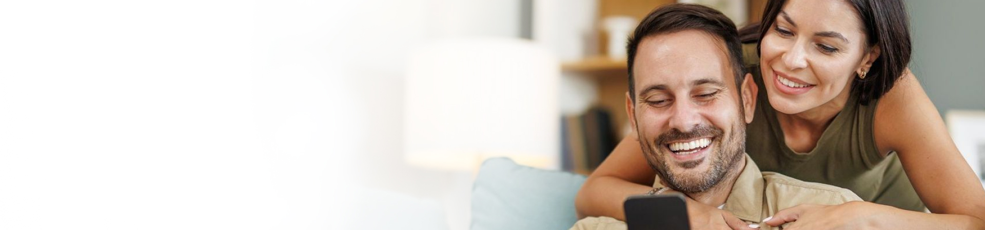Couple smiling looking at phone