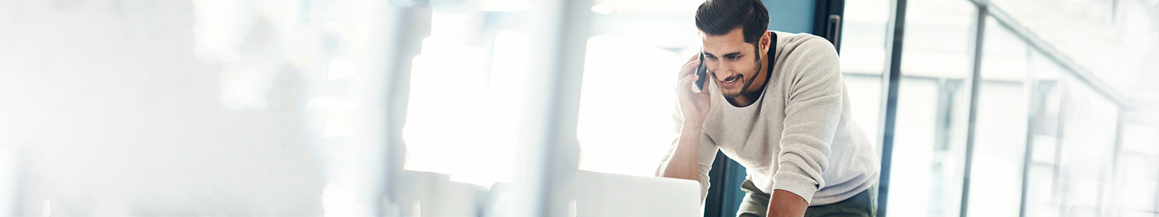 Un jeune homme debout devant son ordinateur portatif